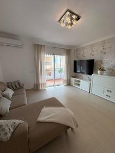 a living room with a couch and a flat screen tv at Apto moderno y familiar junto al mar in Torrox
