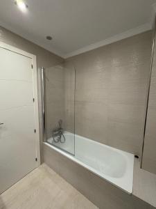 a bathroom with a tub and a glass shower at Apto moderno y familiar junto al mar in Torrox +12 photos