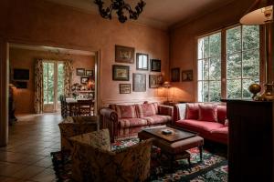 a living room with a red couch and chairs at Villa La Maison Rose in Saint-Julien-en-Born