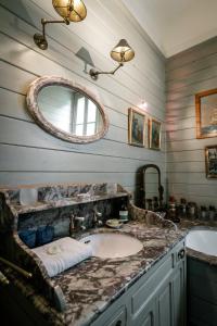 a bathroom with a sink and a mirror at Villa La Maison Rose in Saint-Julien-en-Born +32 photos