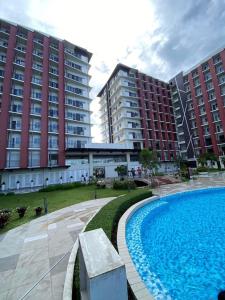 ein Pool vor zwei großen Gebäuden in der Unterkunft Primeworld District Casa De Hanna in Lapu Lapu City