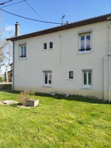 a white house with a green lawn in front of it at Maison accueillante à Margerie-Hancourt avec jardin 91 m² in Margerie-Hancourt
