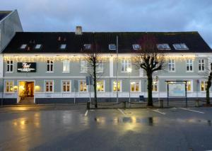 un gran edificio blanco con luces navideñas. en Hotel Thisted, en Thisted