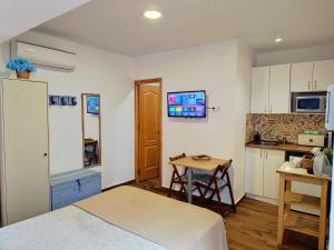 a room with a bed and a kitchen with a table at Apartamento Estudio AZUL in Almuñécar
