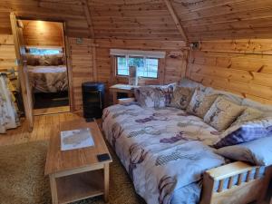 a bedroom with a bed in a log cabin at The Cabin & hot tub at Ashleigh House in Holland Arms Station