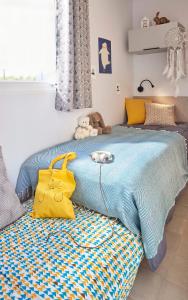 a bedroom with a blue bed with a yellow bag on it at Camping maeva Escapades Parc Valrose in La Londe-les-Maures