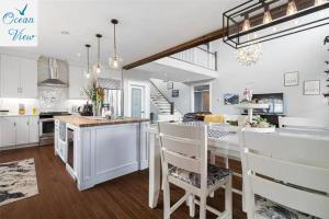 a kitchen with white cabinets and a table and chairs at Scenic Seal Cove Nature Retreat Hot Tubatv Trail in Holyrood