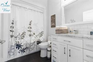 a bathroom with a toilet and a shower curtain at Scenic Seal Cove Nature Retreat Hot Tubatv Trail in Holyrood +38 photos
