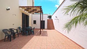 a patio with chairs and a table and a building at Appartamenti Torre Suda by Salento Affitti in Torre Suda
