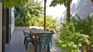 a wooden table and chairs on a patio at Appartamenti Torre Suda by Salento Affitti in Torre Suda