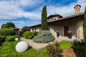 a house with a large tree in the yard at Airport BEA Rooms in Azzano San Paolo