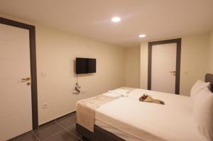 a bedroom with a large white bed with a tv on the wall at Pekin Spa and Suites in Istanbul +3 photos