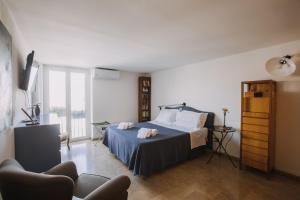 巴勒莫La Rocca sulla Cala by Wonderful Italy的一间带床、电视和沙发的卧室