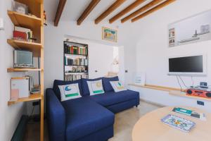 巴勒莫La Rocca sulla Cala by Wonderful Italy的客厅里有一张蓝色沙发和一台电视 更多28张照片