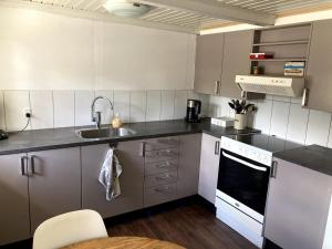 a small kitchen with a sink and a stove at Cozy holiday home in Dalby +22 photos