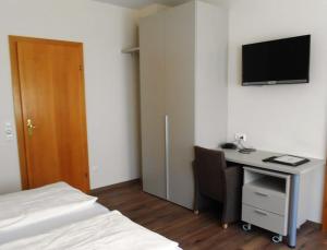 a bedroom with a bed and a desk with a computer at Weingut Gastehaus Palkowitsch in Illmitz
