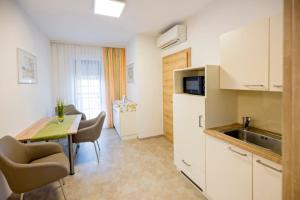 a kitchen and dining room with a table and a sink at Weingut Gastehaus Palkowitsch in Illmitz