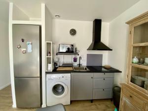 a kitchen with a refrigerator and a washing machine at Charmant T1 bis à Itxassou, proche Thermes, jardin, parking privé, internet, 2 couchages - FR-1-495-136 in Itxassou +9 photos