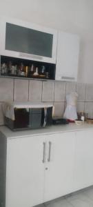 a kitchen with white cabinets and a microwave at Lar YAMAGUCHI COP 30 in Belém