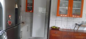 a kitchen with a refrigerator and wooden cabinets at Lar YAMAGUCHI COP 30 in Belém