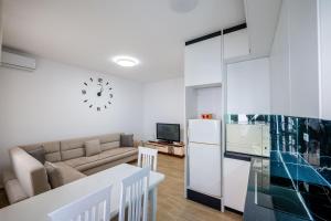 a kitchen and living room with a couch and a refrigerator at Huna Apartment in Sarandë