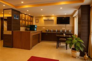 Camera con TV e tavolo con pianta in vaso di Hotel next home a Kathmandu