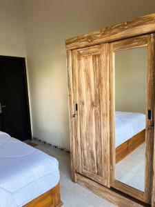 a bedroom with two beds and a wooden cabinet at Brian Homestay in Nusa Dua