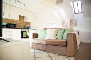 a living room with a couch in a kitchen at Laburnum Cottages - Stratford upon Avon in Stratford-upon-Avon