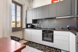 a kitchen with white cabinets and a wooden table at La dimora del Gallo in Concorezzo +12 photos