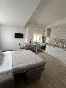 a bedroom with a large bed and a kitchen at FronteMare in Ladispoli