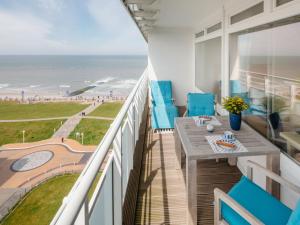 un balcon avec une table et des chaises et une vue sur la plage dans l'établissement Appartement Sonnengelb, à Norderney