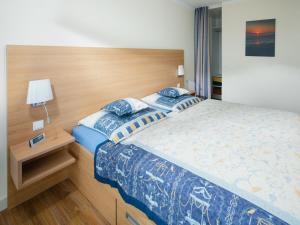 une chambre avec un grand lit avec des draps bleus et blancs dans l'établissement Appartement Sonnengelb, à Norderney