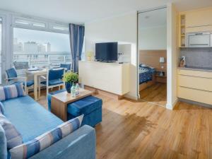 un salon avec un canapé, une télévision et une table dans l'établissement Appartement Sonnengelb, à Norderney