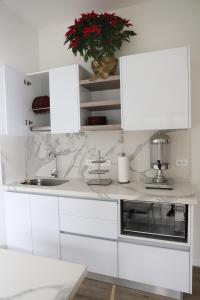 a white kitchen with white cabinets and a sink at Hotel Colina Inn Escazu in San Rafael
