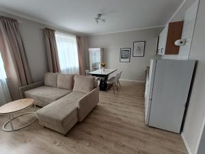 a living room with a couch and a refrigerator at Apartament na Kopernika in Augustów +2 photos