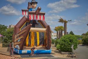 Eine Person steht vor einer großen aufblasbaren Aufschrift in der Unterkunft Camping 2 Plages et Océan - Maeva in Châtelaillon-Plage