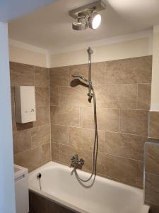 a bathroom with a bath tub with a shower at City Apartments in Krefeld