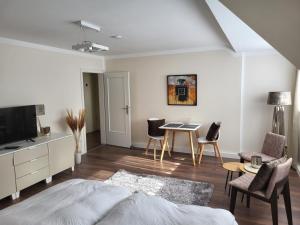 a living room with a bed and a table and chairs at City Apartments in Krefeld