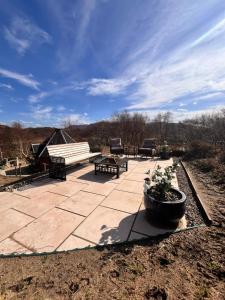 un patio in pietra con panca e panca di Glenwood glamping pod a Morar Altre 29 foto