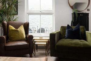 a living room with two chairs and a table at Peaceful & Tranquil Cottage With Private Terrace at 'The Pink House' in Falmouth