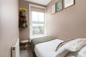 a bedroom with a bed and a window at Peaceful & Tranquil Cottage With Private Terrace at 'The Pink House' in Falmouth