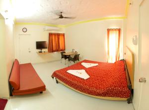 奥兰加巴德Hotel Panchavati的一间卧室配有红色的床和一张书桌