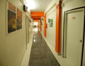 奥兰加巴德Hotel Panchavati的走廊上设有橙色墙壁和长走廊