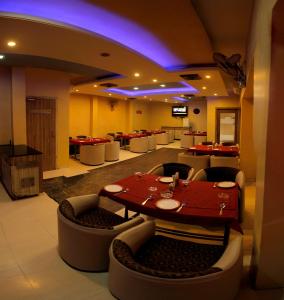 奥兰加巴德Hotel Panchavati的有红色桌子和椅子的餐厅