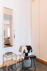 a room with a chair and a mirror at Youhosty - Brera 17 in Milan +52 photos