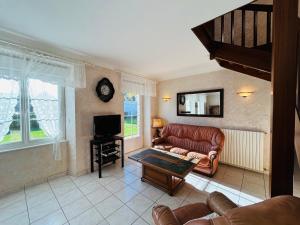a living room with a couch and a tv at Maison située dans longère 6 à 8 personnes proche du bourg de Guidel - ALARIC in Guidel