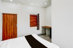 PālHotel O GLR INN的一间卧室配有一张床和一扇木门 更多21张照片