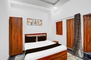 PālHotel O GLR INN的一间卧室配有一张带木制家具的床。