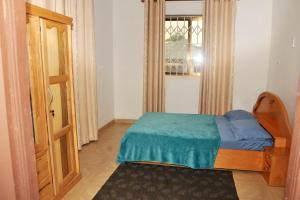 a small bedroom with a bed with a blue blanket at Stunning 2 Bedroom Affordable pl in Kumasi