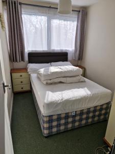 two beds in a small room with a window at Parkview Retreat in Hemsby